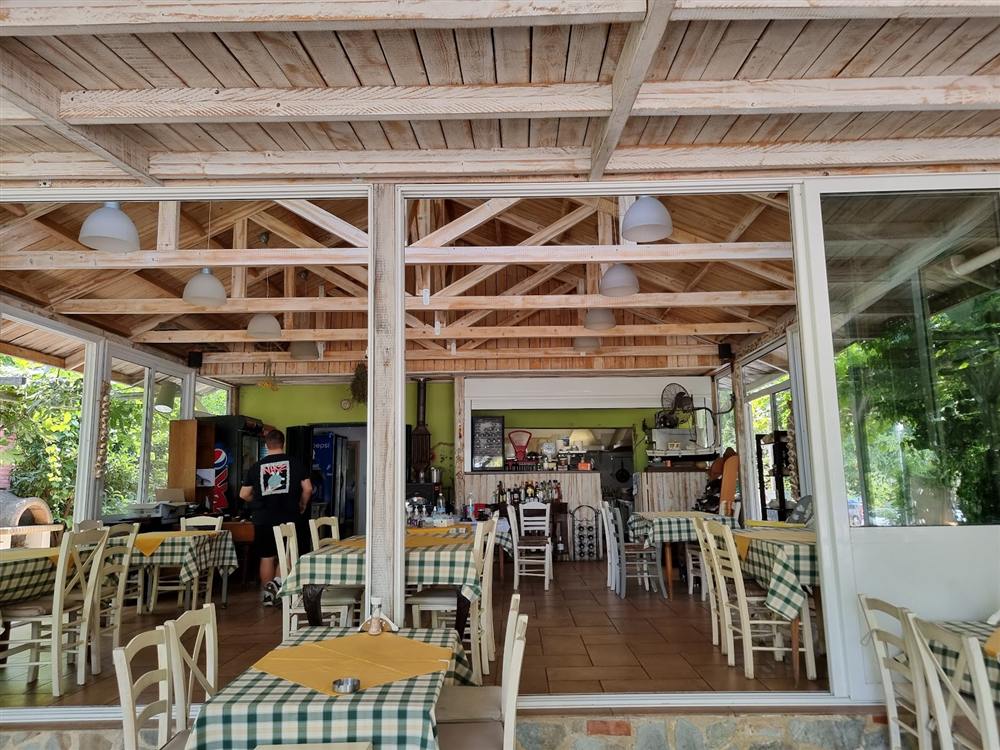 Inside the tavern — green checked tablecloths and white chairs