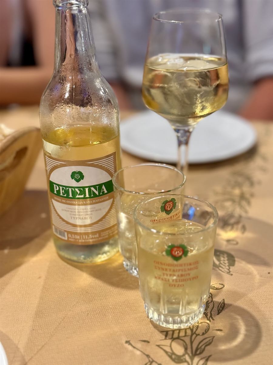 A bottle of retsina and glasses on the table